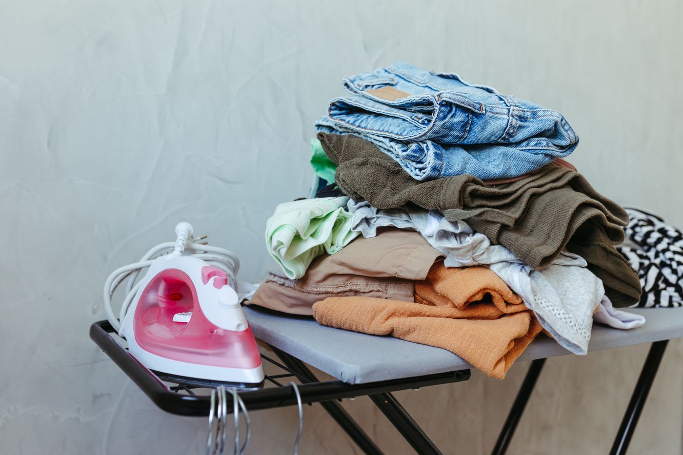 Iron and folded clothing on ironing board
