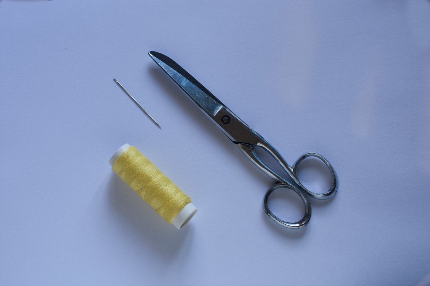 Needle thread and scissors on a table